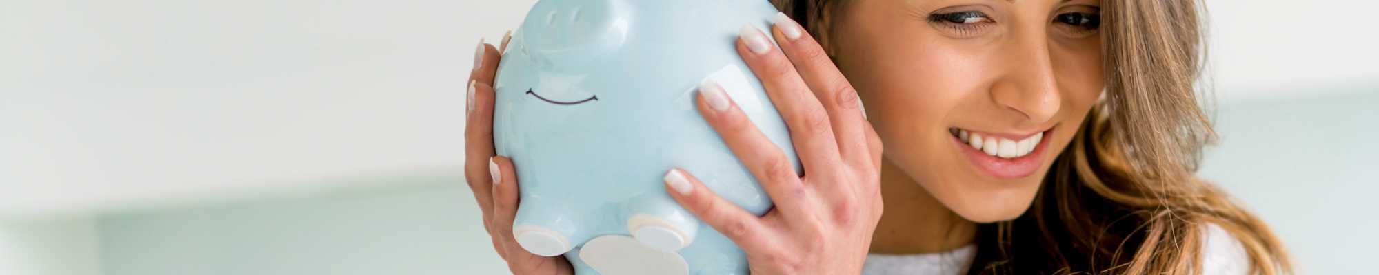 woman smiling and holding a piggy bank